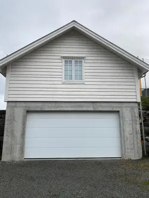 a white garage door with a window on top at Stort hus med tømmervegger og fjordutsikt in Stranda