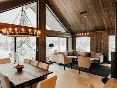 a living room with a table and chairs at Modern Cabin With Mountain View By Syningtoppen in Torpo