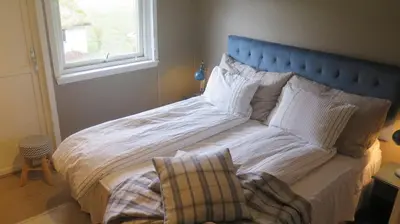 a large bed with a blue headboard in a bedroom at Sara's Fjord View House in Stadlandet