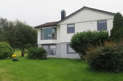a house with a dog in the window of it at Sara's Fjord View House in Stadlandet
