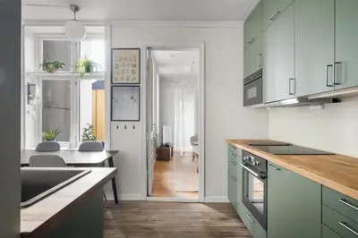 a kitchen with white walls and green cabinets at Colorful Apartment - Right Next to Grieghallen! in Bergen