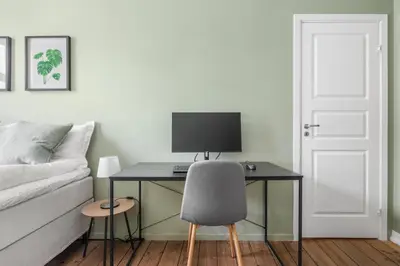 a desk with a computer and a chair in a room at Colorful Apartment - Right Next to Grieghallen! in Bergen