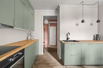 a kitchen with green and white cabinets and a sink at Colorful Apartment - Right Next to Grieghallen! in Bergen