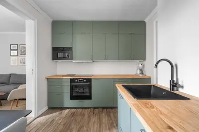 a kitchen with green cabinets and a sink at Colorful Apartment - Right Next to Grieghallen! in Bergen