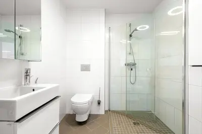 a bathroom with a toilet and a sink and a shower at A cozy three bedroom apartment for rent in Heimdal