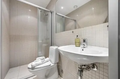 a bathroom with a sink and a toilet and a shower at Roomsly - Cozy Hilltop Hideout in Central Bergen in Bergen
