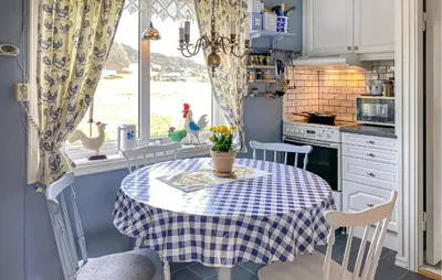 a kitchen with a table with a blue and white table cloth at 3 Bedroom Cozy Apartment In Myklebost in Myklebost