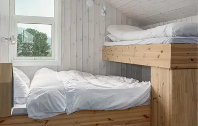a bedroom with two bunk beds and a window at 2 Bedroom Cozy Home In Edland in Vågsli