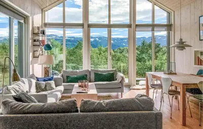 a living room with a table and a large window at 2 Bedroom Cozy Home In Edland in Vågsli