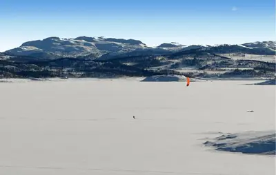 a person standing on a frozen lake with mountains in the background at Awesome Apartment In Rauland in Rauland