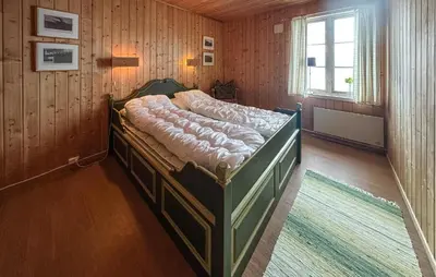 a bed in a room with wooden walls and a window at Awesome Apartment In Rauland in Rauland