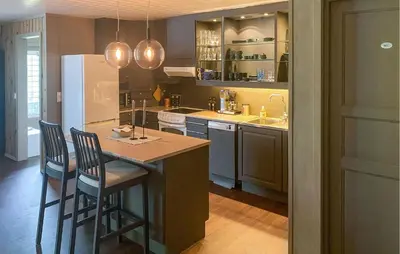 a kitchen with a island with chairs and a refrigerator at Nice Apartment In Tisleidalen With Wifi in Tisleidalen