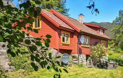 a red house with yellow windows in a field at Nice Home In Valen With House Sea View in Valen