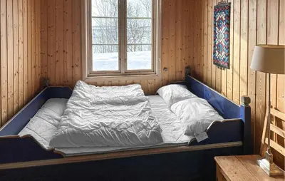 a bed in a wooden room with a window at Nice Apartment In Rauland With Wifi in Rauland