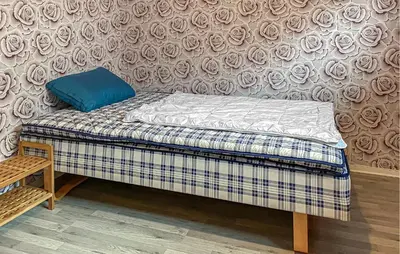 a small bed with a blue pillow on top of it at Pet Friendly Apartment In Harøy in Steinshamn