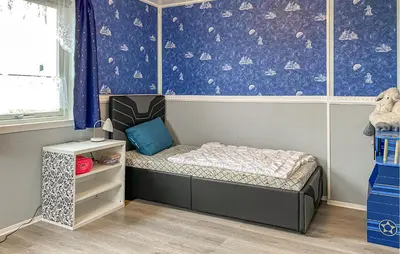 a small bed in a room with a wall with planets at Pet Friendly Apartment In Harøy in Steinshamn