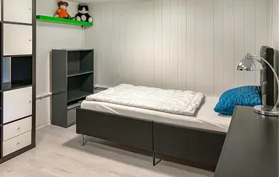 a small bedroom with a bed and a desk at Pet Friendly Apartment In Harøy in Steinshamn