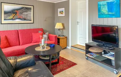 a living room with a red couch and a tv at Lovely Apartment In Myklebost With Wifi in Myklebost