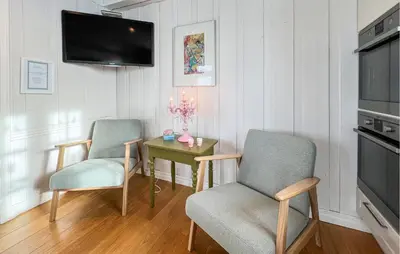 a living room with two chairs and a table with a tv at Lovely Home In Aurdal With Sauna in Aurdal