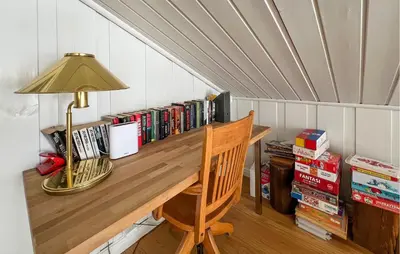 a desk in a room with a lamp and books at Lovely Home In Aurdal With Sauna in Aurdal