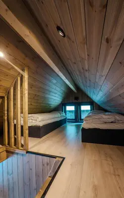 two beds in a room with wooden ceilings at Flåm Minisuite in Aurland