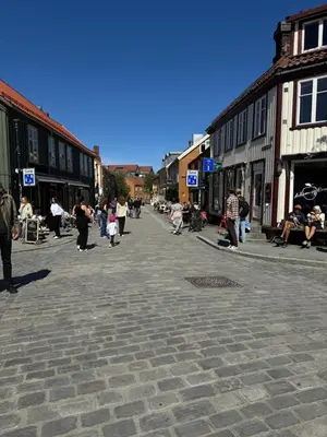 a group of people walking around a cobblestone street at Stor attraktiv studioleilighet i sentrum in Trondheim