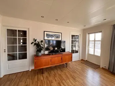 a living room with a flat screen tv on a wooden table at Cozy house with sea view close to Ålesund in Havsteinen