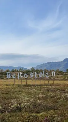 a sign in a field with mountains in the background at Handicap-friendly apartment with 3 bedrooms in Beitostøl