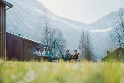 a group of people sitting on the side of a barn at Vårsetra in Bø