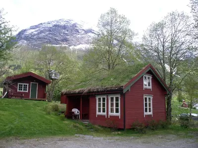 a small red house with a grass roof at Vårsetra in Bø