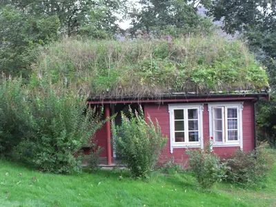 a small red house with a grass roof at Vårsetra in Bø