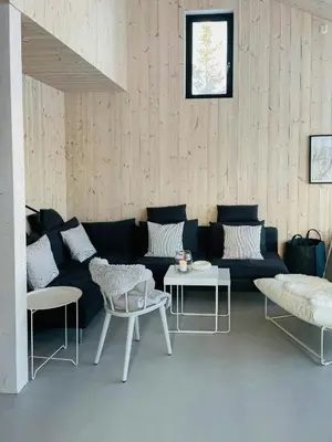 a living room with a black couch and tables at Cozy Cabin At The Gateway To Jotunheimen in Vaga