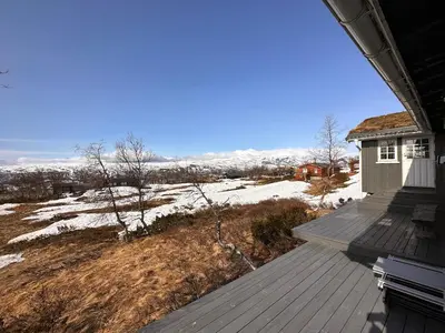a view from the deck of a house with snow at A Peaceful Mountain Retreat in Beitostøl
