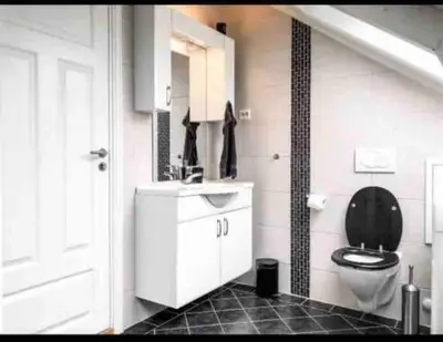 a bathroom with a toilet and a sink and a sink at Penthouse Ålesund city center in Ålesund