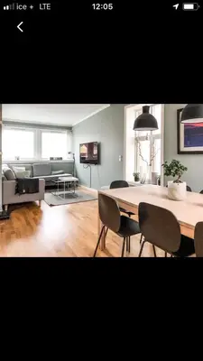 a living room with a table and chairs and a couch at Penthouse Ålesund city center in Ålesund
