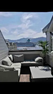 a couch sitting on a patio with a view of the ocean at Penthouse Ålesund city center in Ålesund