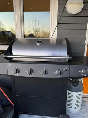 a grill sitting in front of a house at Romslig leilighet med to soverom pluss hems med dobbeltseng in Bergen