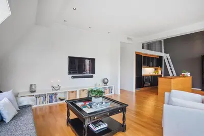 a living room with a couch and a table at Romslig leilighet med to soverom pluss hems med dobbeltseng in Bergen
