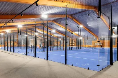 an indoor tennis court with lights on the court at Romslig leilighet med to soverom pluss hems med dobbeltseng in Bergen