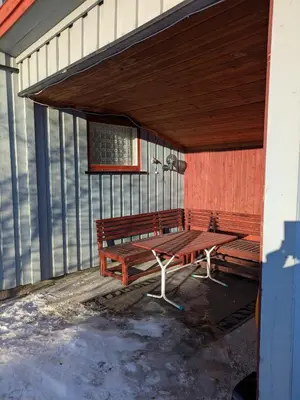 a wooden bench sitting on the side of a building at Three bedroom home with an amazing mountain view! in Oppdal