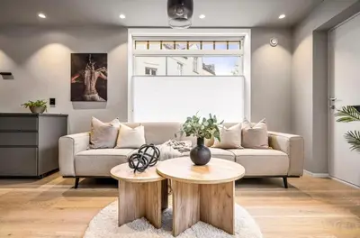 a living room with a couch and two wooden tables at Townhouse - 700 meters from Bryggen in Bergen