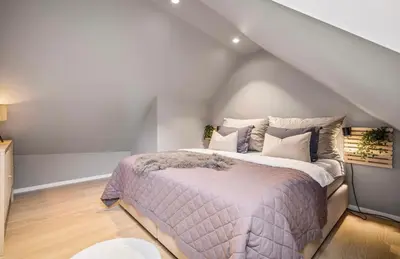 a bedroom with a large bed in a attic at Townhouse - 700 meters from Bryggen in Bergen