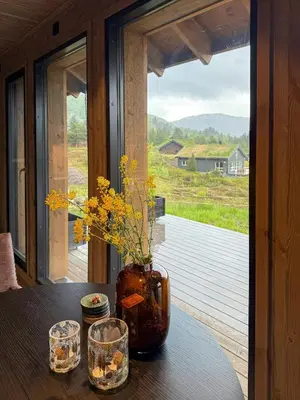 a vase with flowers in it sitting on a table at Modern Cabin With Panoramic Views In Stryn in Stryn
