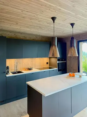 a kitchen with blue cabinets and two pendant lights at Modern Cabin With Panoramic Views In Stryn in Stryn