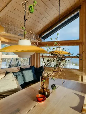 a room with a wooden table with aandelier at Bright Cabin In Eggedals Beautiful Mountains in Eggedal