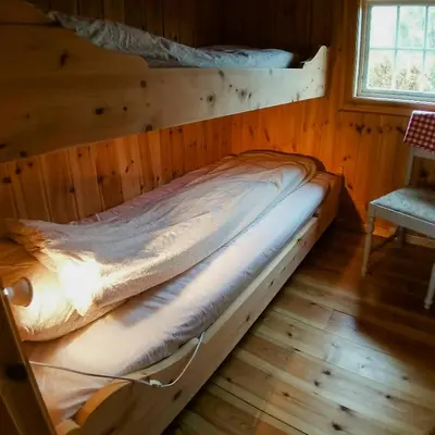 a bed in a wooden room with a window at Historic Log Cabin By Rondane National Park in Lårgard
