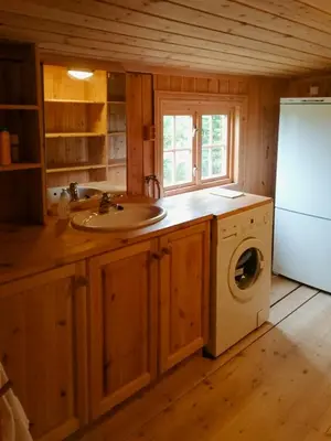 a kitchen with a sink and a washing machine at Historic Log Cabin By Rondane National Park in Lårgard