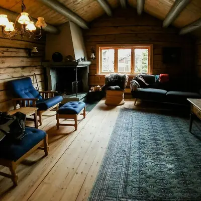 a living room with a couch and chairs and a fireplace at Historic Log Cabin By Rondane National Park in Lårgard