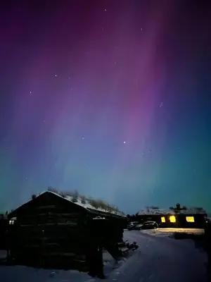 a house in the snow at night with a purple sky at Historic Log Cabin With Views Of Rondane in Ringebu
