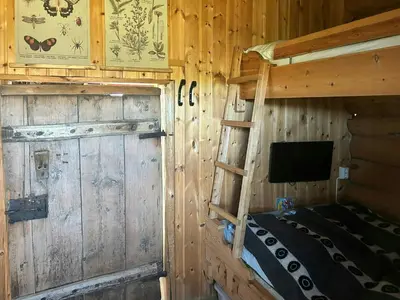 a bedroom with a bunk bed and a tv in a cabin at Historic Log Cabin With Views Of Rondane in Ringebu